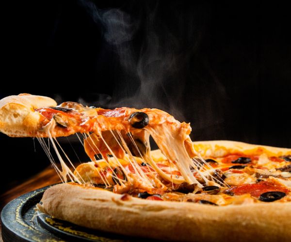 A steaming hot, fresh pizza slice on a plate. 