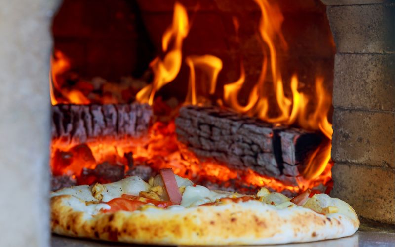 cook pizza in a wood fired oven