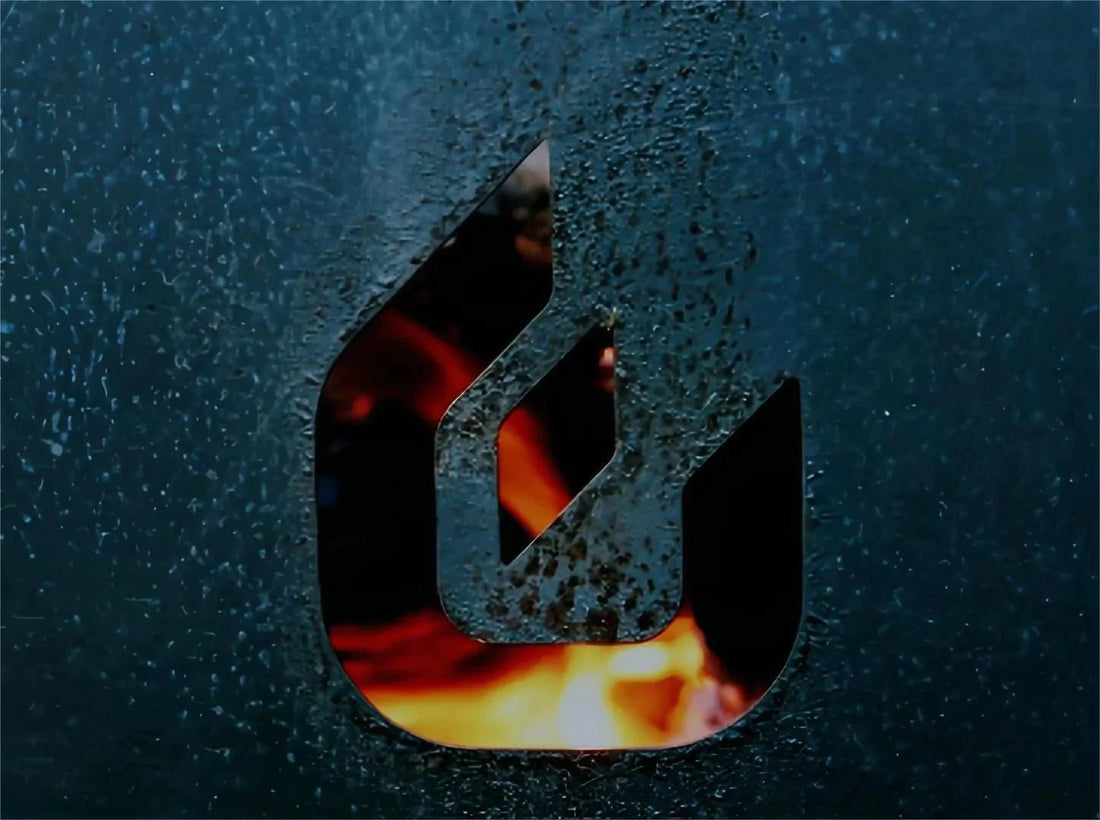 A flame is visible through a cut-out flame design in textured dark metal.