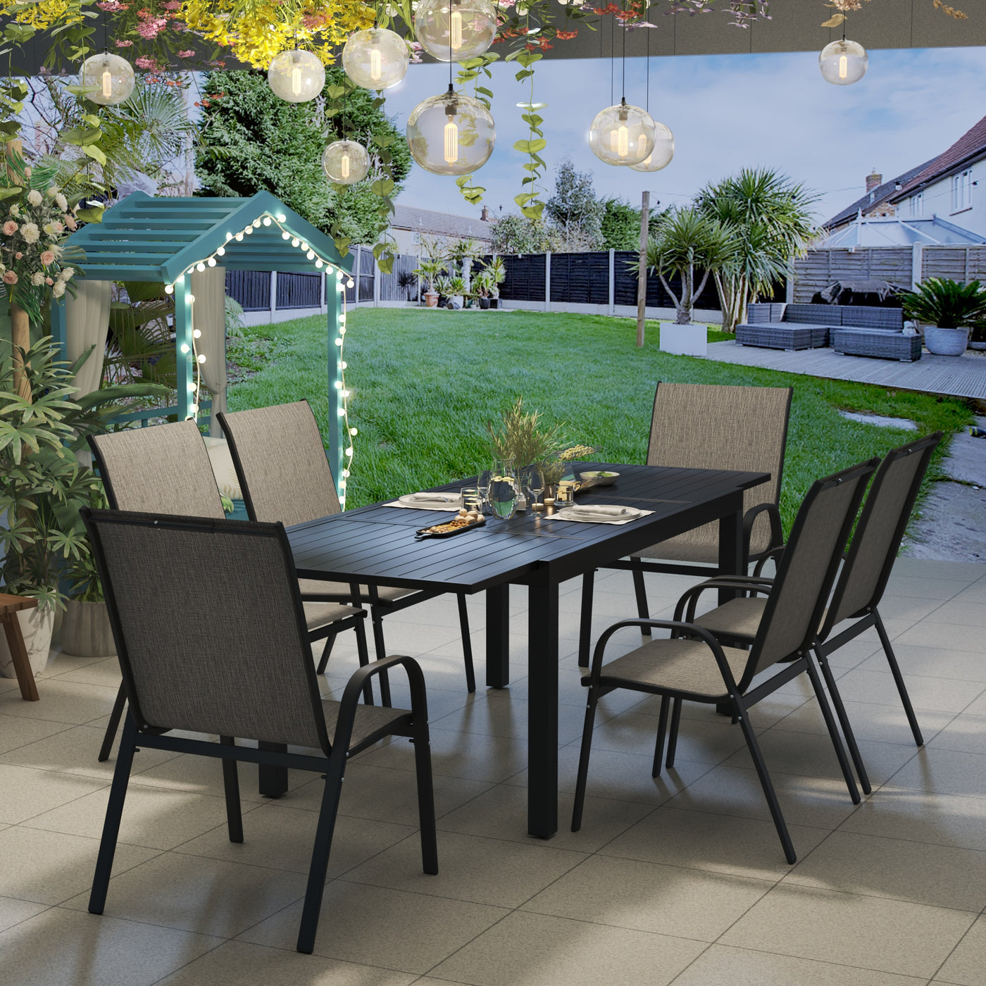Outdoor dining area with a Pizzello Aluminum Patio Extendable Dining Table, string lights, and a garden gazebo in the background.